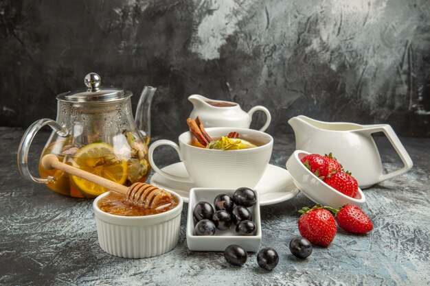 Vista frontal taza de té con aceitunas y miel en la superficie oscura desayuno de comida de la mañana