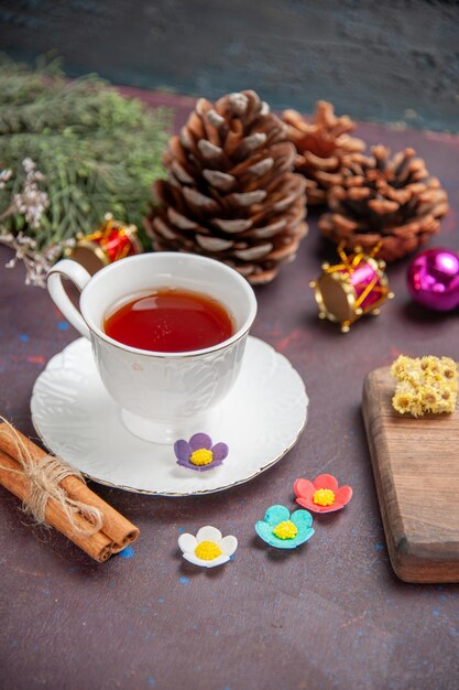 Vista frontal de una taza de té con canela en el espacio oscuro