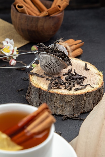 Vista frontal taza de té con canela marrón sobre fondo oscuro comida ceremonia de color desayuno almuerzo comida de limón