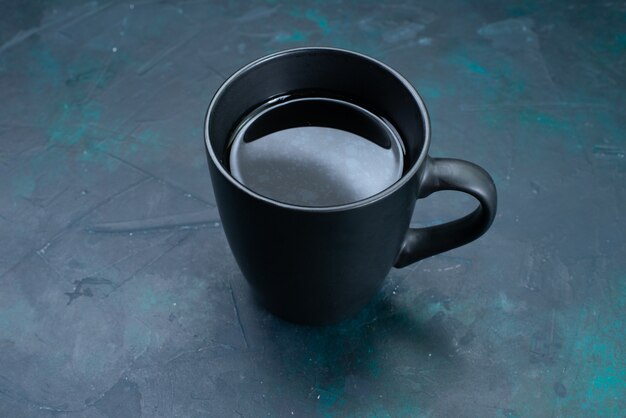 Vista frontal de la taza de té en el color de la bebida de té de escritorio azul oscuro