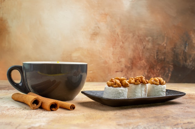 Vista frontal de una taza de té con confituras de nueces en la mesa de luz