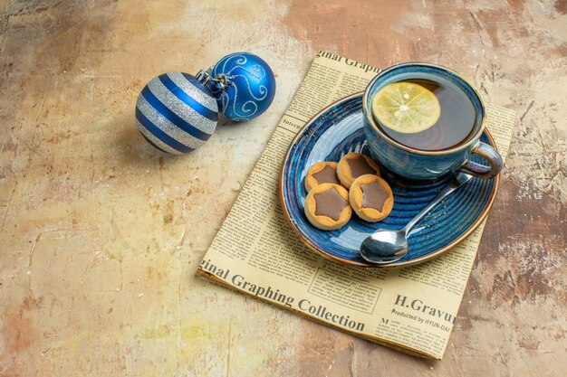 Vista frontal taza de té con galletas en la mesa de luz color pastel ceremonia de postres desayuno