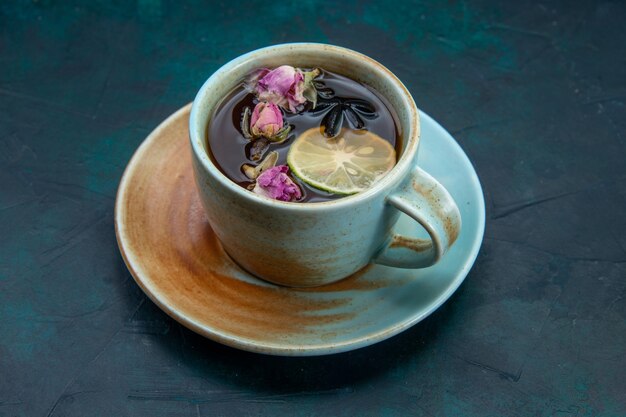 Vista frontal de la taza de té con limón y flor