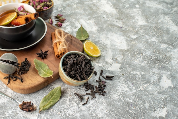 Vista frontal taza de té con limón en el fondo claro ceremonia de flores sabor matutino fruta desayuno comida color