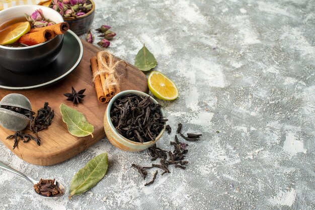 Vista frontal taza de té con limón en el fondo claro ceremonia de flores sabor matutino fruta desayuno comida color