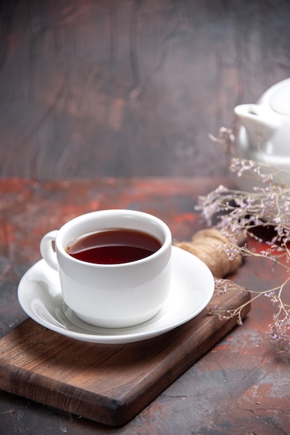 Vista frontal de la taza de té en la mesa oscura galleta oscura