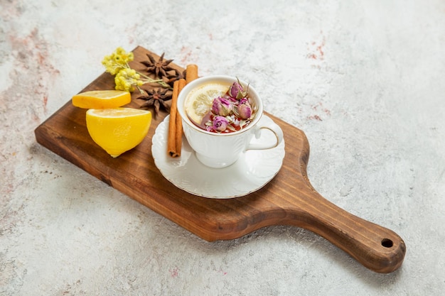 Vista frontal de una taza de té con rodajas de limón en un espacio en blanco