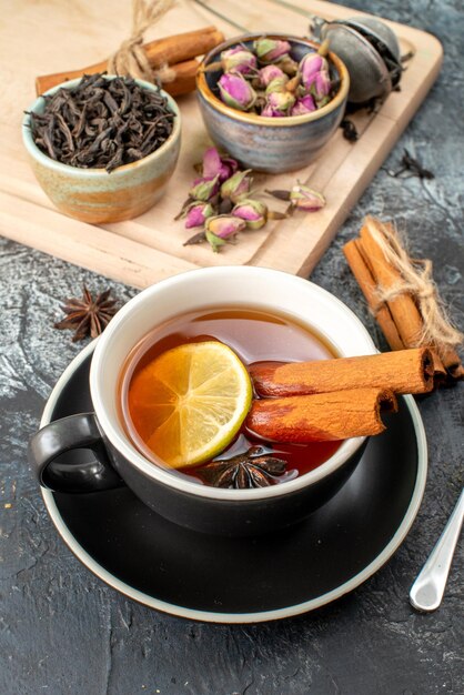 Vista frontal de té de limón en taza y tetera sobre fondo gris comida color mañana fruta desayuno foto ceremonia