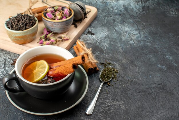 Vista frontal de té de limón en taza y tetera sobre fondo gris comida color mañana fruta desayuno foto ceremonia