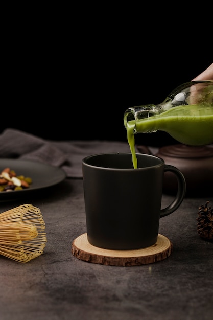 Vista frontal del té matcha vertido en taza