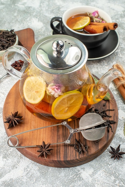 Vista frontal tetera con té té de limón sobre fondo claro sabor color mañana comida fruta ceremonia flor