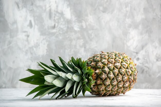 Vista frontal de toda la piña dorada que cae fresca en la pared de hielo con espacio libre