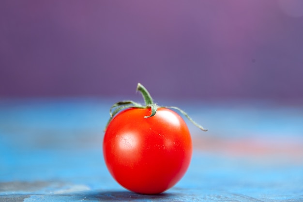 Vista frontal de tomate rojo fresco en la mesa de color rosa azul foto comida ensalada de verduras