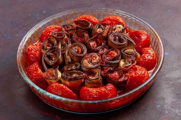 Vista frontal de tomates y berenjenas de harina de verduras cocidas en la superficie oscura
