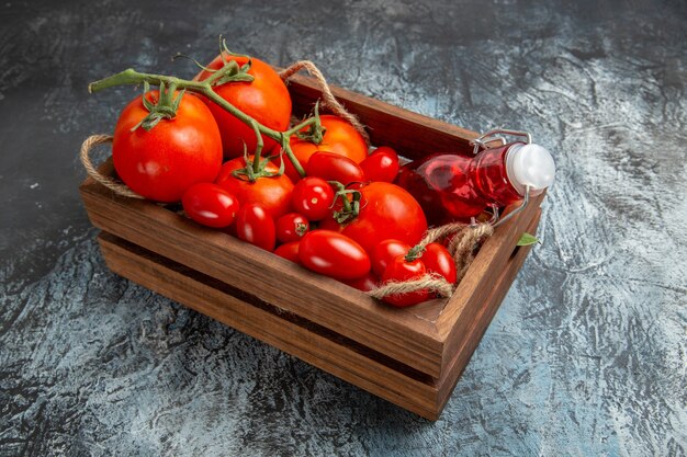 Vista frontal de tomates frescos con cereza dentro de la caja