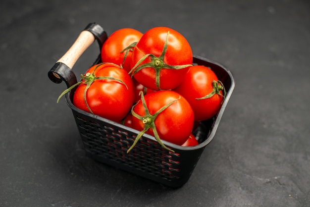 Vista frontal de tomates rojos frescos dentro de la canasta sobre un fondo oscuro ensalada de verduras comida de color maduro