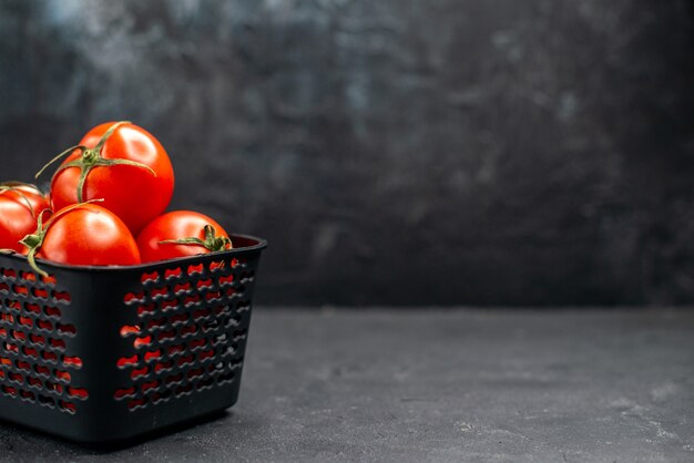 Vista frontal de tomates rojos frescos dentro de la cesta sobre fondo oscuro ensalada de color maduro comida foto espacio libre