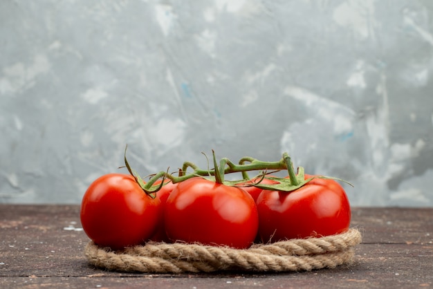 Vista frontal tomates rojos frescos maduros y enteros en blanco, con cuerdas frutas vegetales baya colorante alimentario