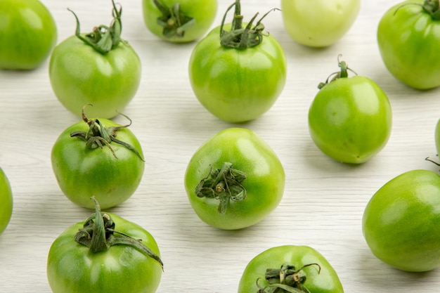 Foto gratuita vista frontal de los tomates verdes en el escritorio blanco color ensalada madura foto comida dieta vida sana