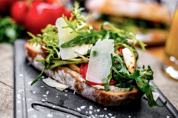 Vista frontal tostadas con verduras rúcula y queso en una bandeja