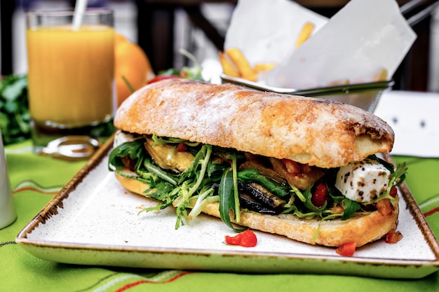 Vista frontal tostadas con verduras y salsa de pesto con papas fritas y jugo de naranja