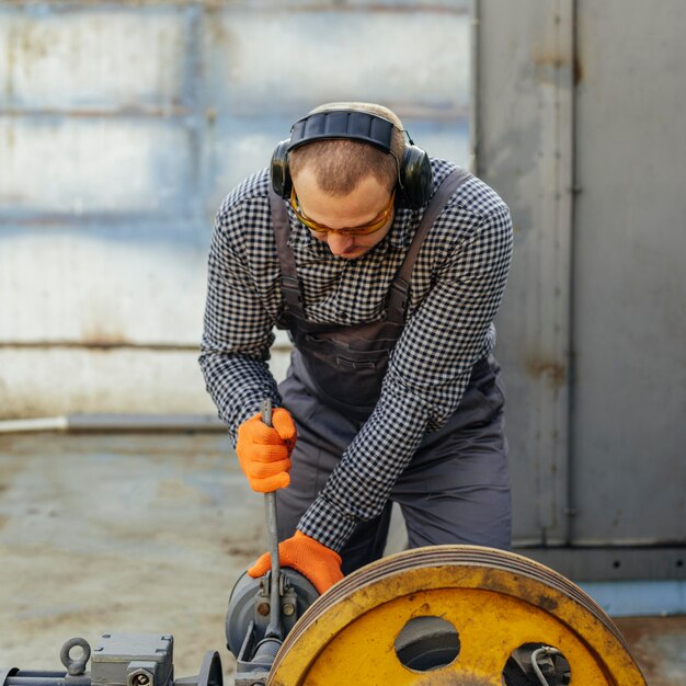 Vista frontal del trabajador con guantes y auriculares