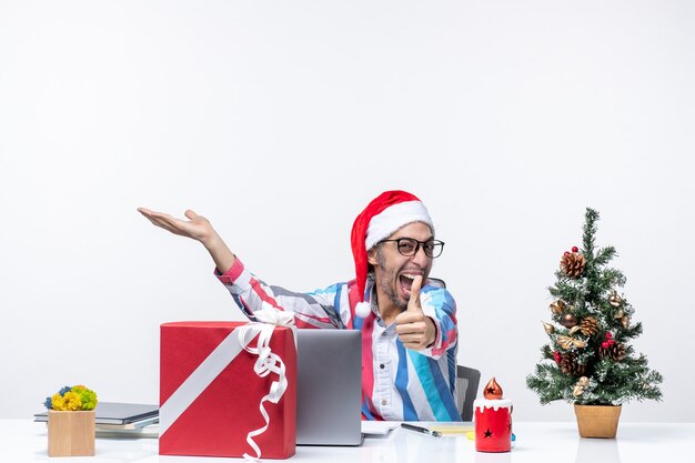 Foto gratuita vista frontal trabajador masculino sentado en su lugar de trabajo sintiéndose emocionado trabajo navidad emoción empresarial