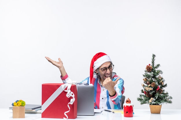 Foto gratuita vista frontal del trabajador masculino sentado en su lugar de trabajo trabajo navidad emoción empresarial