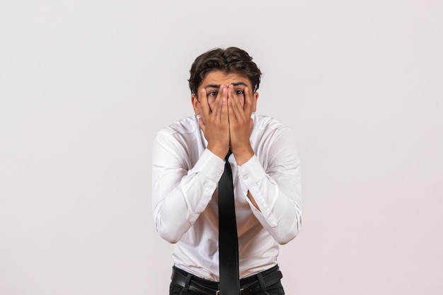 Vista frontal del trabajador de oficina masculino con cara de sorpresa en la pared blanca trabajo de trabajo masculino