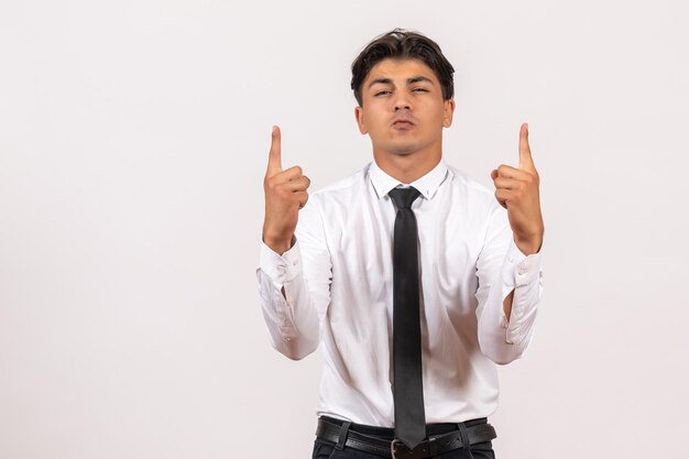 Vista frontal del trabajador de oficina masculino de pie sobre la pared blanca trabajo de oficina humano trabajo masculino