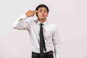 Foto gratuita vista frontal trabajador de oficina masculino posando en la pared blanca trabajo de oficina trabajo humano masculino