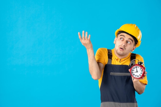 Vista frontal del trabajador de sexo masculino en uniforme amarillo con relojes en azul