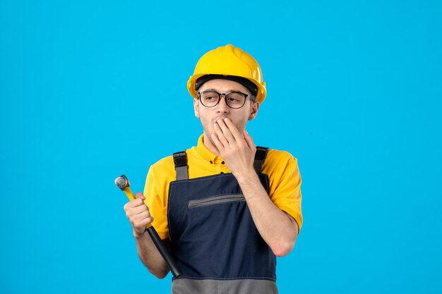 Vista frontal del trabajador de sexo masculino en uniforme amarillo sobre azul