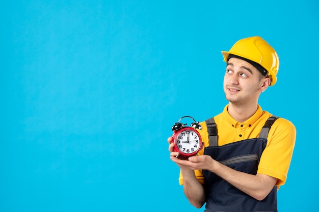 Vista frontal del trabajador de sexo masculino en uniforme con relojes en azul