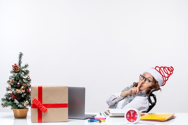 Vista frontal trabajadora sentada ante su lugar de trabajo pidiendo estar en silencio trabajo de oficina trabajo de navidad de negocios