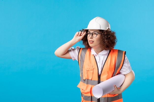 Foto gratuita vista frontal de la trabajadora en uniforme en la pared azul