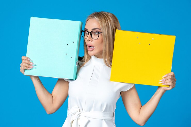 Foto gratuito vista frontal de la trabajadora en vestido blanco sosteniendo una carpeta diferente en la pared azul