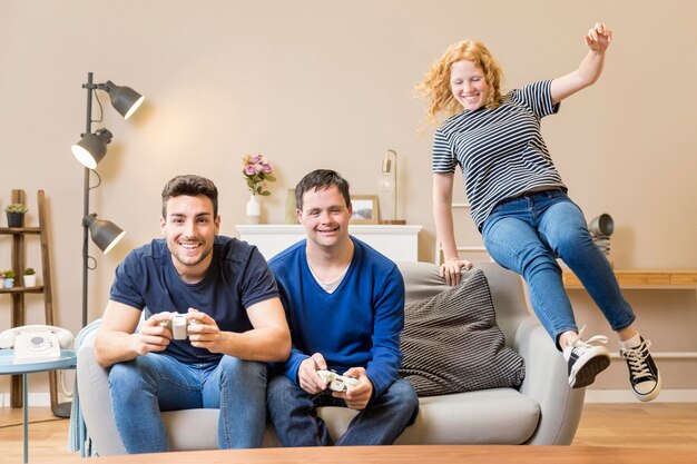 Foto gratuita vista frontal de tres amigos jugando videojuegos