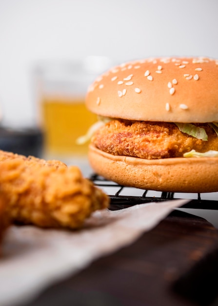 Vista frontal de trozos de pollo frito y hamburguesa en bandeja