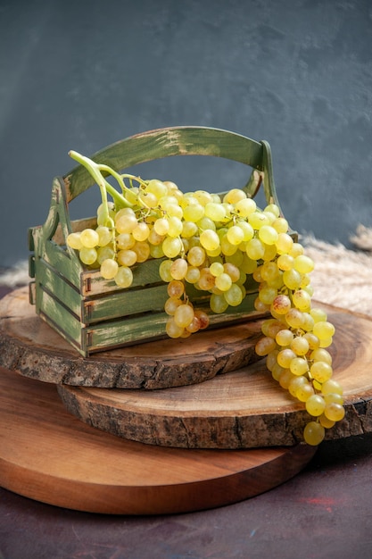 Vista frontal uvas frescas frutas verdes y maduras en la superficie oscura uva de vino fruta madura planta de árbol fresco