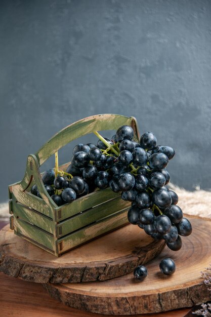 Vista frontal uvas suaves frescas frutas oscuras en la superficie oscura uva de vino frutas maduras planta de árbol