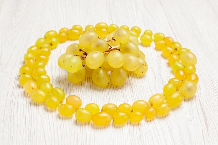 Foto gratuito vista frontal de las uvas verdes frescas haciendo un círculo en el color del jugo suave del vino de la fruta del escritorio blanco