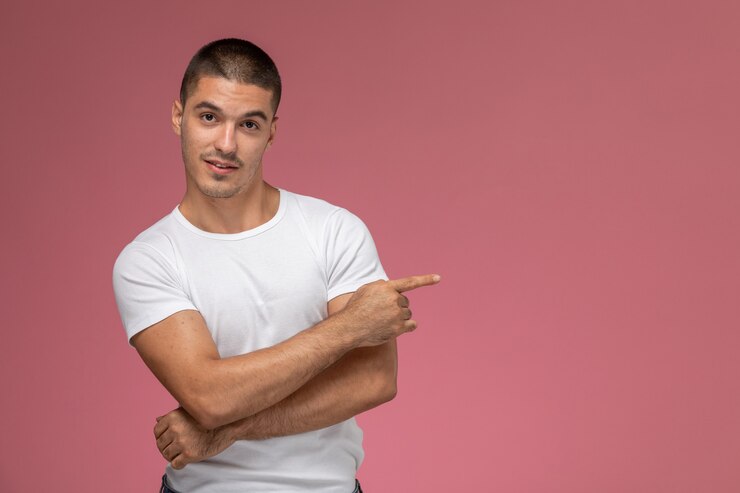 Foto gratuito vista frontal del varón joven en camisa blanca simplemente posando sobre el fondo rosa