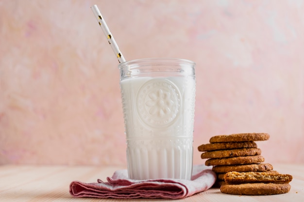 Foto gratuita vista frontal vaso de leche con paja y galletas