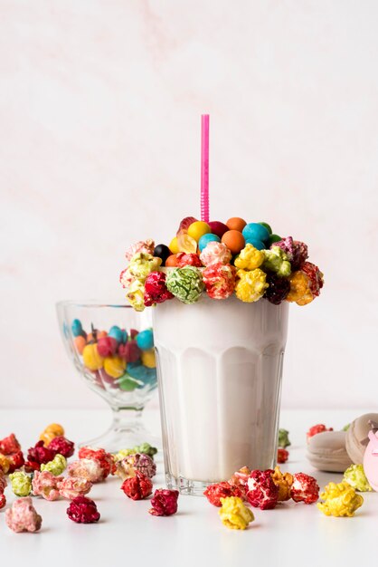 Vista frontal del vaso de postre con dulces coloridos