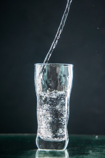 Vista frontal de un vaso de refresco en una bebida oscura, color, champán, agua de navidad