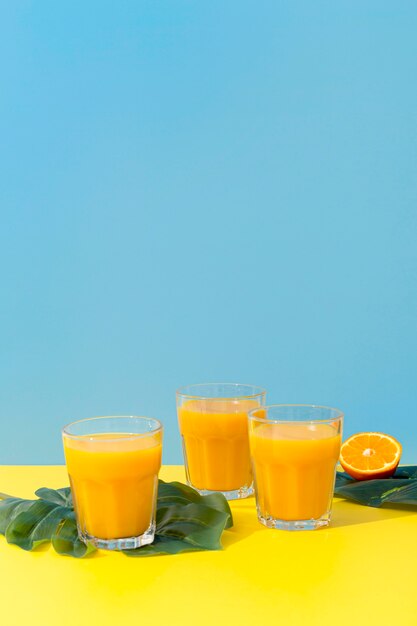 Vista frontal vasos frescos de batidos de naranja