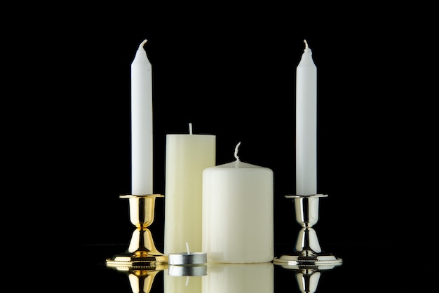 Vista frontal de velas blancas sobre tono negro