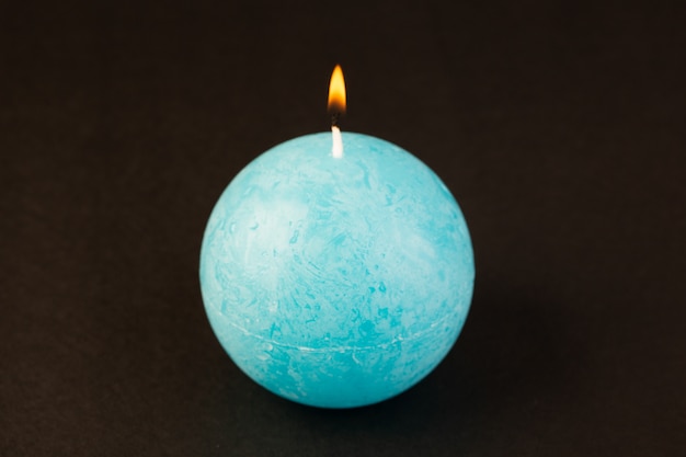 Foto gratuita una vista frontal de velas en forma redonda de color azul diseñado en el fondo oscuro brillante decoración de fuego