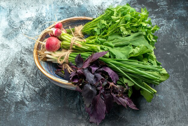 Vista frontal de verduras frescas con rábano sobre fondo oscuro-claro color foto comida de ensalada madura